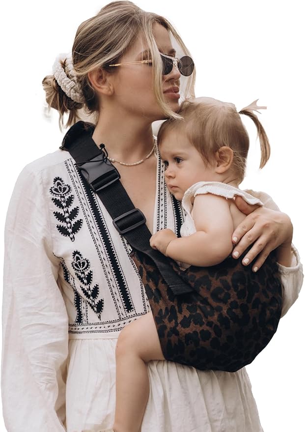 Maman au parc avec fille dans porte bebe naissance