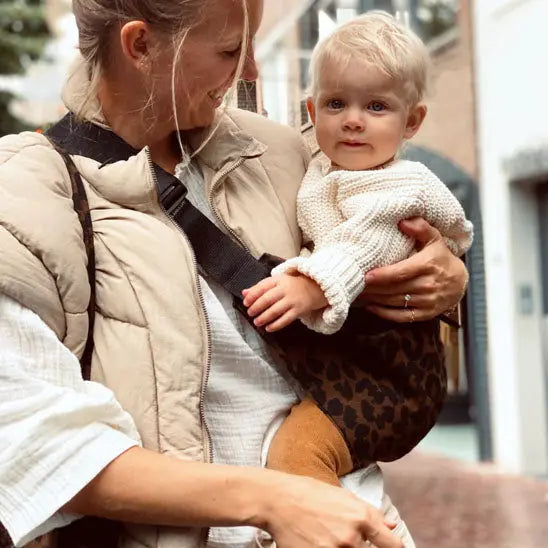 Maman regarde bebe dans porte bebe naissance