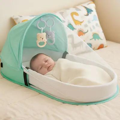 bebe dort dans lit bebe de voyage vert