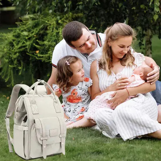 famille au parc assis et sac a langer devant eux