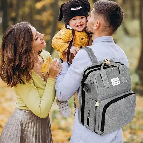 famille au parc avec sac pour bebe au dos