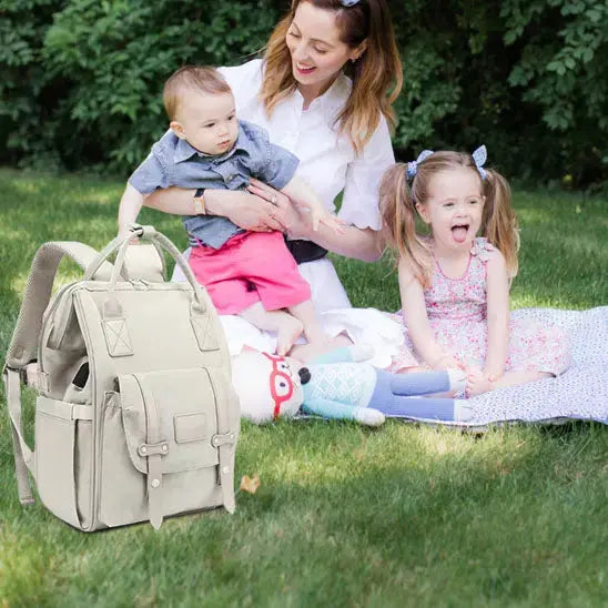 famille au parc rigole et sac a langer devant eux