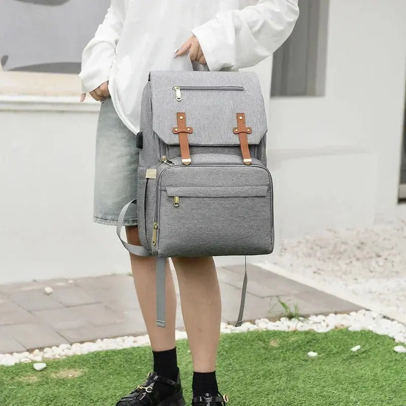 femme avec sac a dos a langer en main