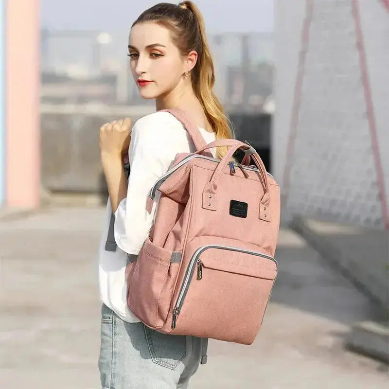femme marche avec grand sac a langer rose au dos