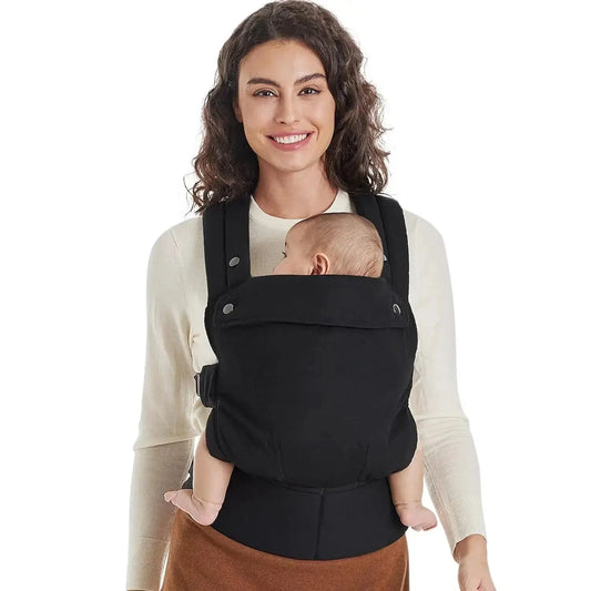 femme sourit avec bebe dans porte bebe noir