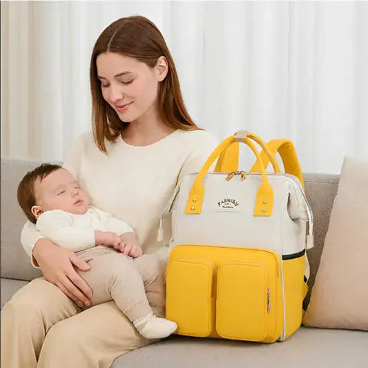 maman assise sofa avec bebe et sac a langer a dos