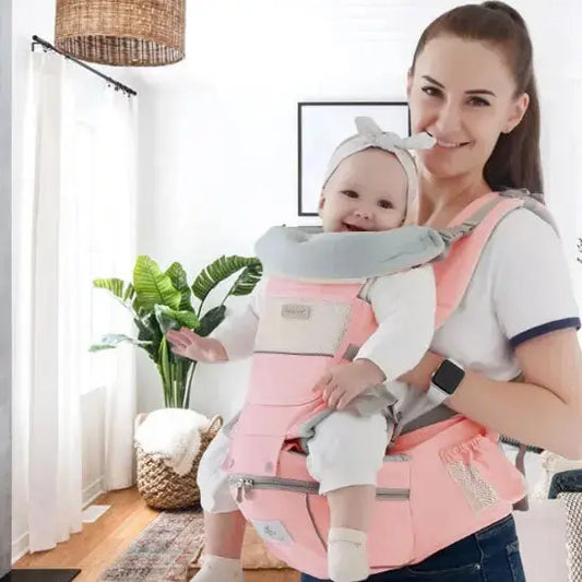 maman au salon sourit avec bebe dans porte bebe
