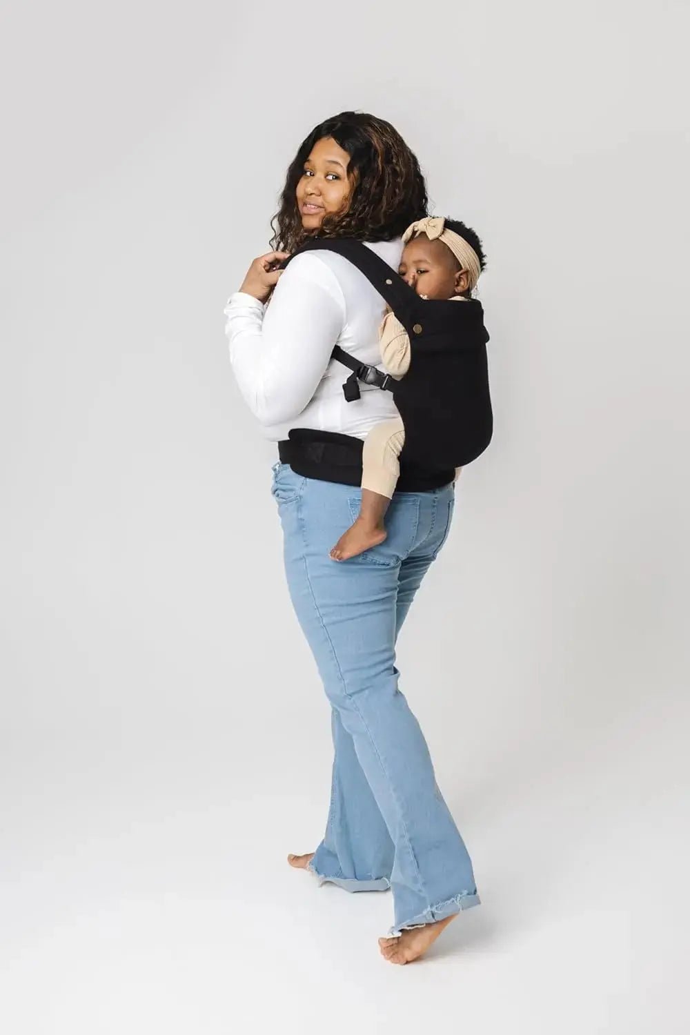 maman avec bebe au dos dans porte bebe