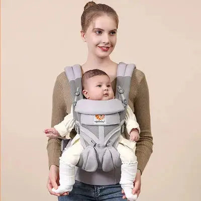 maman sourit avec bebe dans porte bebe gris