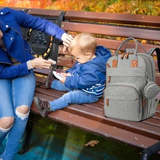mere sur banc avec sac a langer