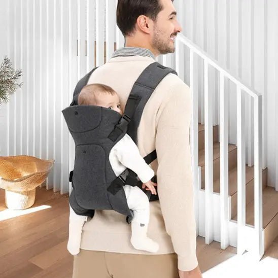 papa salon avec bebe au dos dans porte bebe mei tai