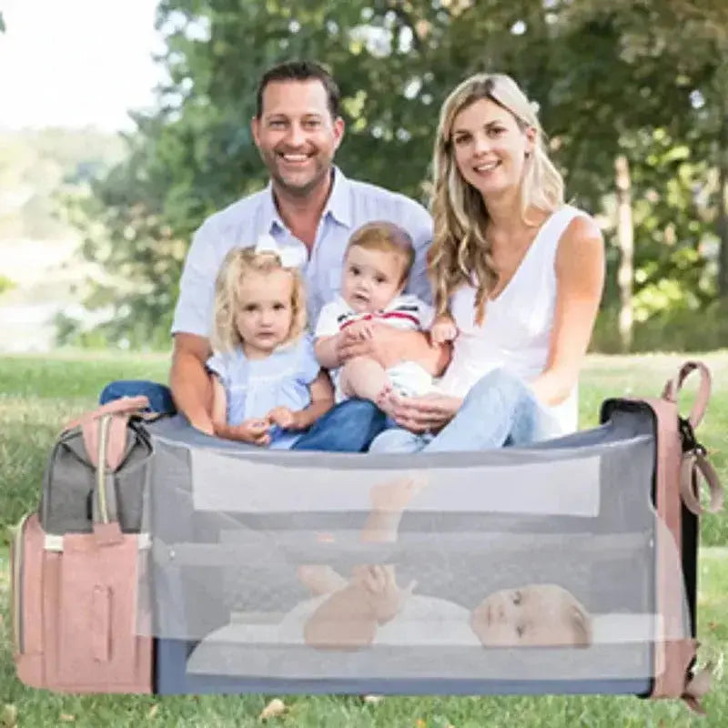 parents jardin avec bebe dans sac a langer lit rose