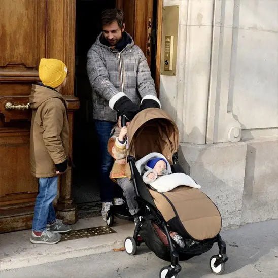pere sort avec enfants et bebe dans poussette avec chanceliere