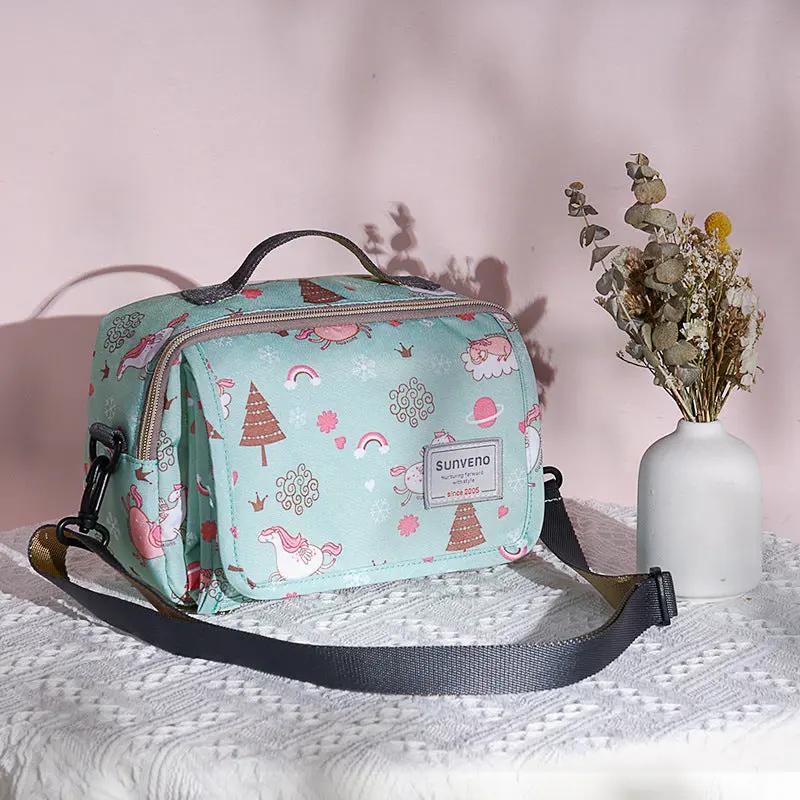 sac a langer avec tapis de change vert sur table