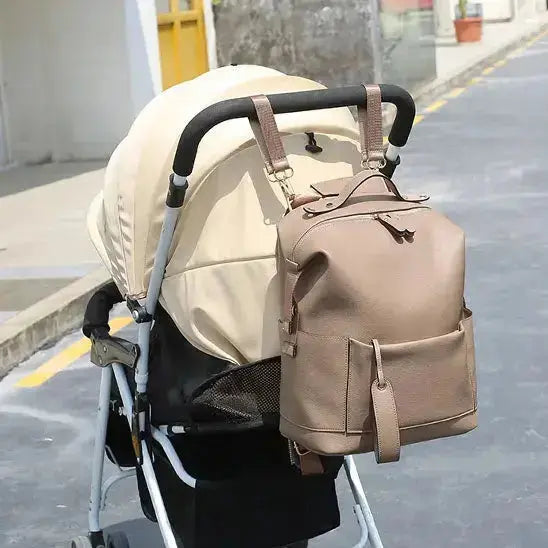 sac a langer beige suspendu sur poussette