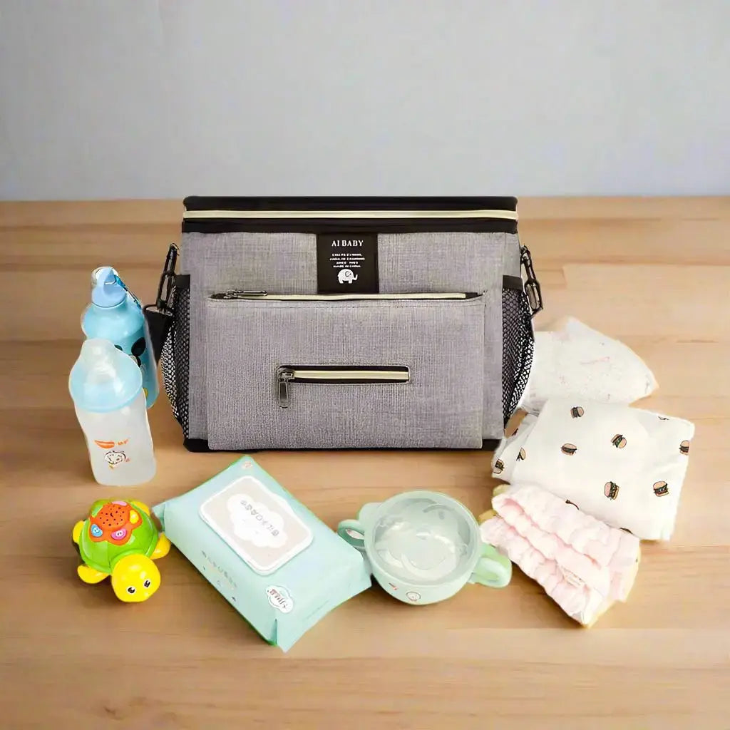 sac a langer gris sur table avec effets bebe autour