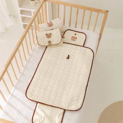 tapis a langer beige dans un lit