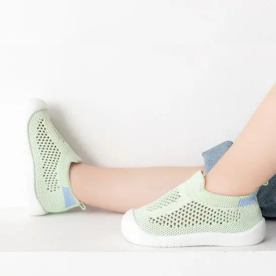 bebe tend les pieds avec chaussure bebe vert