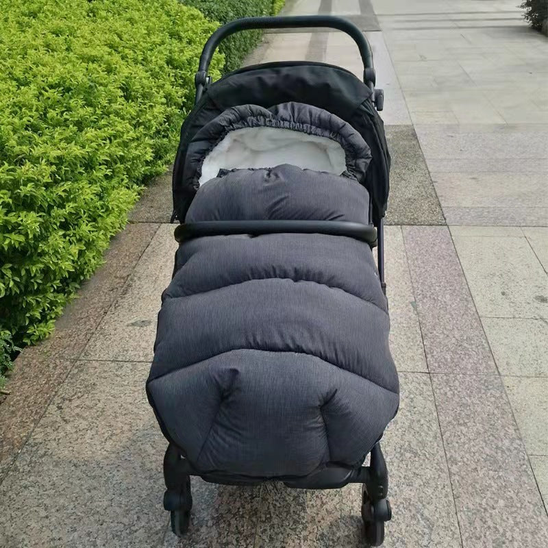 chanceliere nid d ange dans poussette noir sur chemin