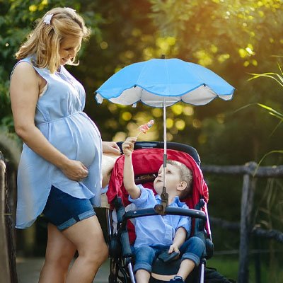 femme au parc avec ombrelle pour poussette bleu