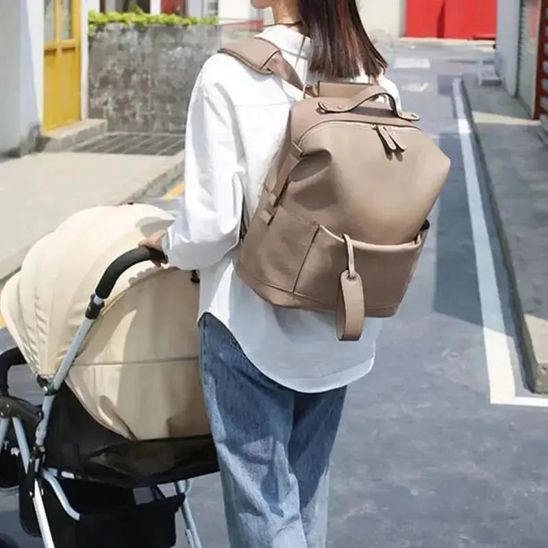 femme roule poussette avec sac a langer beige