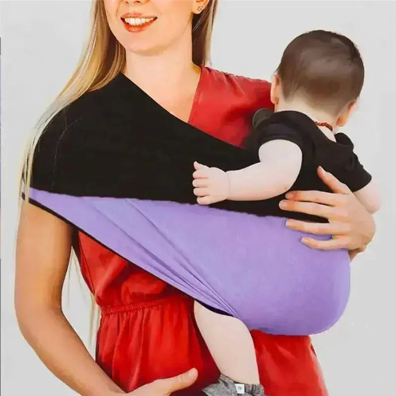 femme sourrit portant bebe avec echarpe de portage