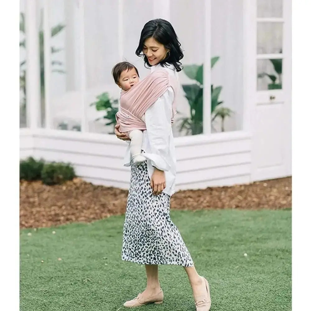 maman au jardin avec bebe dans bebe portage echarpe rose
