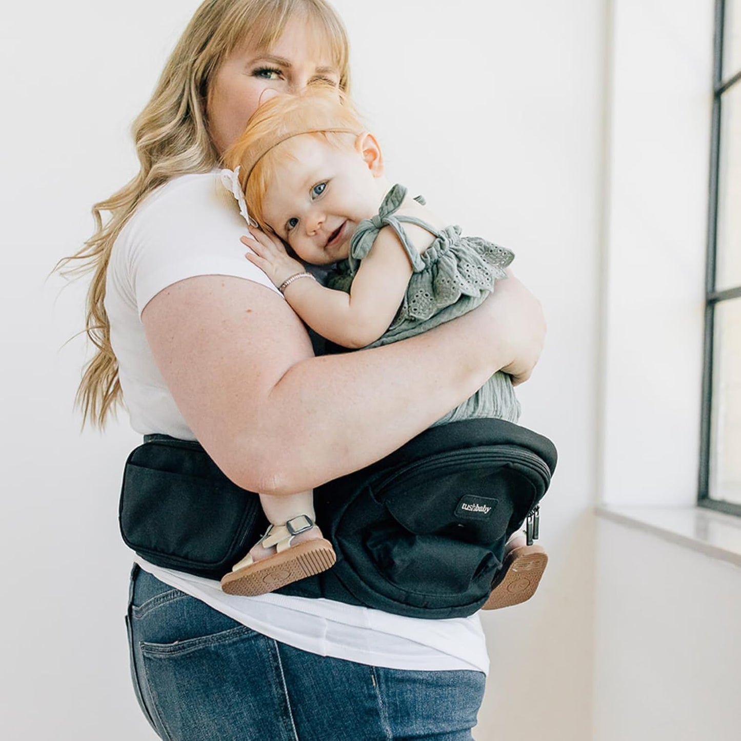 maman avec fille dans porte bebe assis