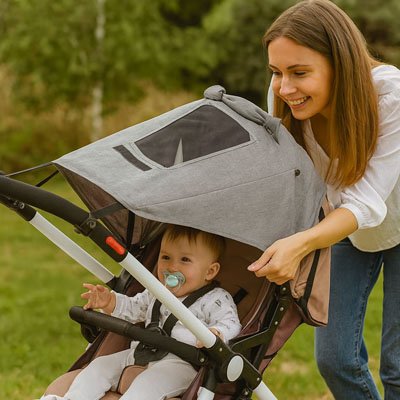 maman bebe dans poussette avec pare soleil pour poussette
