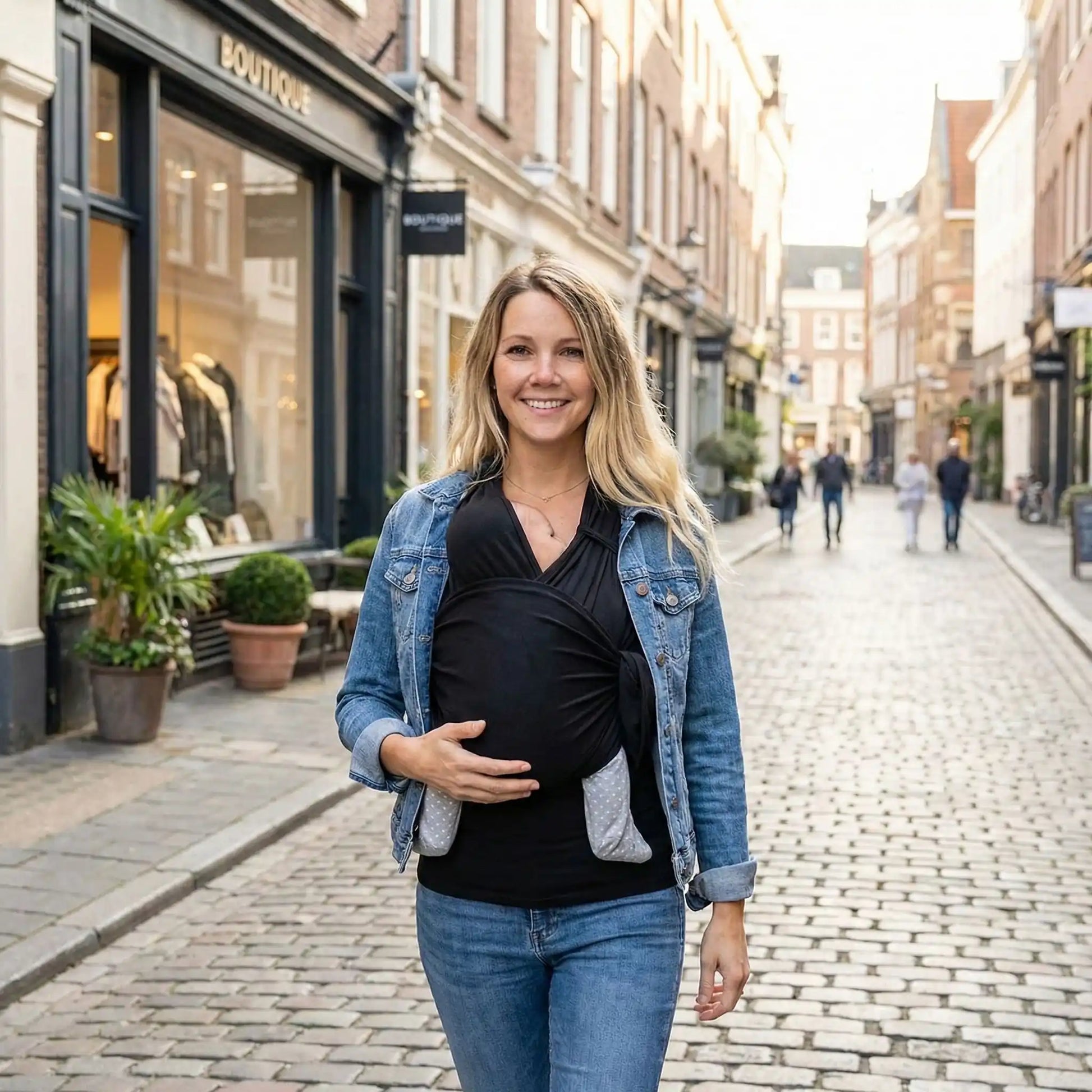 maman en ville avec bebe dans tee shirt porte bebe